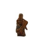 A 19th century Japanese wooden netsuke of Hotei standing holding a fan with red and blue lacquer