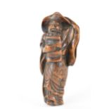 A Japanese Edo period (18th/19th century) wooden netsuke of a scholar holding his hat on, 9.5cm h