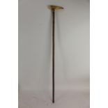 A late 19th/early 20th century walking stick having a walrus tusk handle with a gold plated tip