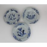 Three Chinese Qing, 18th century blue and white plates, each decorated with flowers and foliage to
