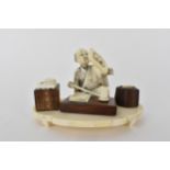 A Japanese Meiji period ivory and wood Okimono of a craftsman holding a mirror with a book in