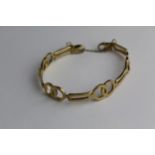 A gold bracelet with interlocking circles and bars, with a safety chain, tested as 9ct gold, 11.8g