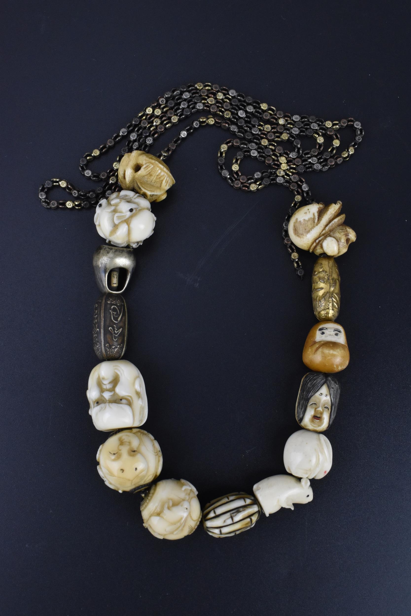 A 19th century Japanese ojime bead necklace, with carved ivory, bone, and metal ojimes, modelled