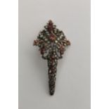 A late 19th/early 20th century silver gilt turban brooch of scrolled leaf design set with rubies and