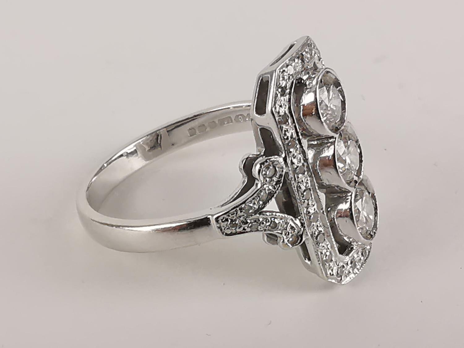 An 18ct white gold Art Deco style ring with three central diamonds