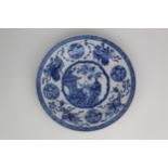 A Chinese Kangxi blue and white plates, decorated with a boy on a veranda by a large vase of
