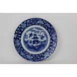 A Chinese, Kangxi blue and white plate decorated with a pagoda and cranes within a floral border and