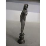 An Art Nouveau patinated bronze desk seal in the form of a standing nude woman, engraved initials to