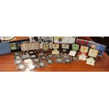 A mixed lot of British commemorative coins to include a box of sterling silver proof Crowns for