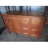 A late 19th/early 20th century walnut cabinet having carved floral decoration with three drawers