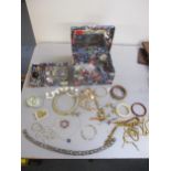 A jewellery box containing a selection of costume jewellery to include necklaces, brooches,