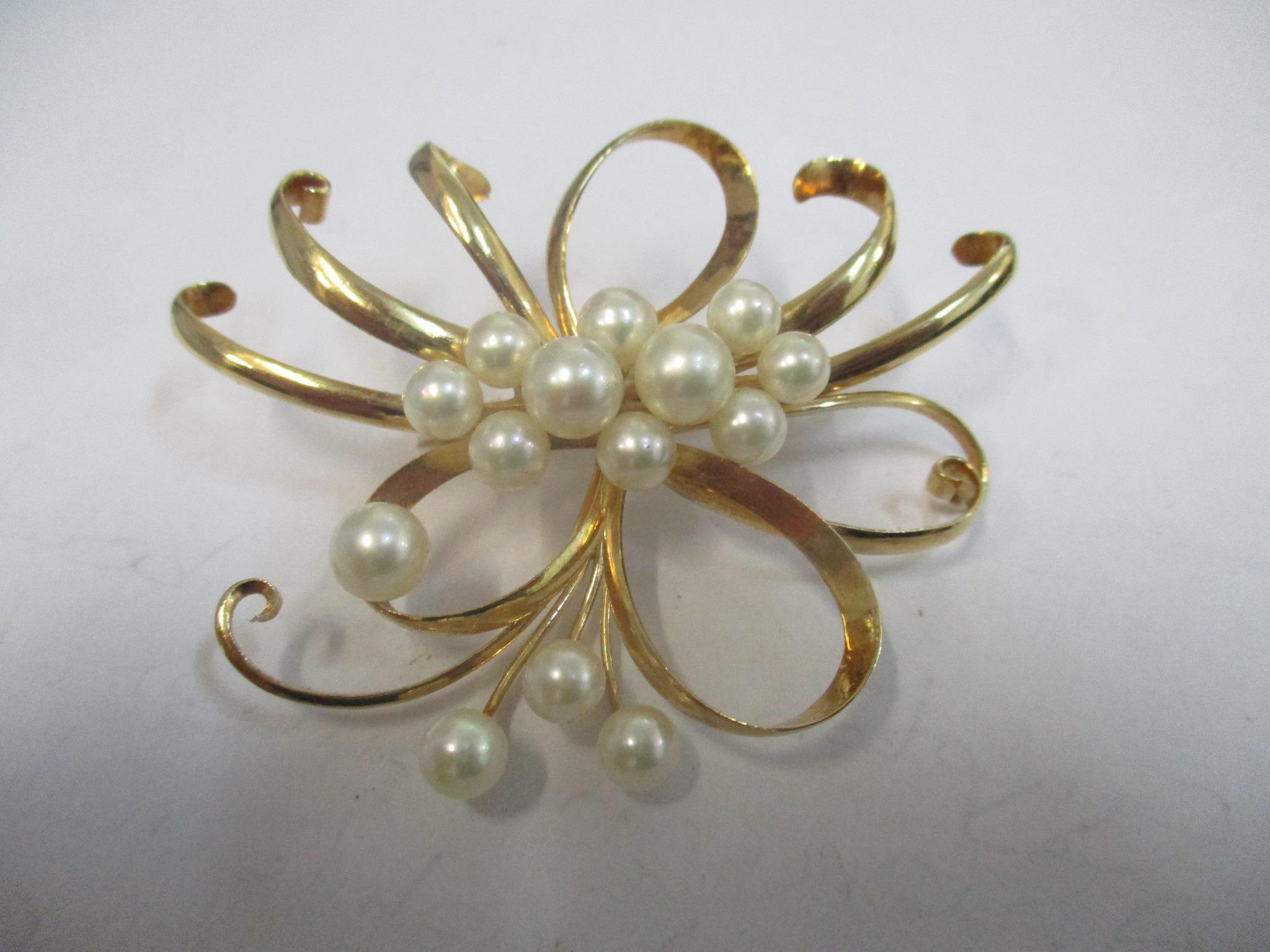 A yellow metal brooch with fourteen pearls, tests as gold, 18.8g Location: