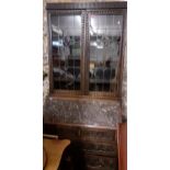 A late Victorian carved oak bureau bookcase, twin leaded glazed display doors with Scottish Arts &