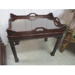 A 20th century mahogany silver tray table having candle slides, pierced supports and square formed