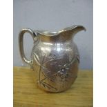 A sterling silver embossed cream jug decorated with insects and floral design, 95.6g Location: