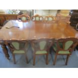 A reproduction mahogany Simbeck wind out dining table with two extra leaves on, on carved, fluted an