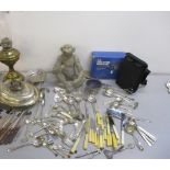 A mixed lot of silver plated flatware and other items to include a brass oil lamp with glass smoke