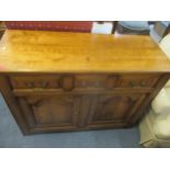 A small side cupboard having three short drawers above twin cupboard doors on slab feet 82cm x 107cm