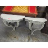 A pair of vintage painted wall hanging demi lune shelves having scroll carved decoration and