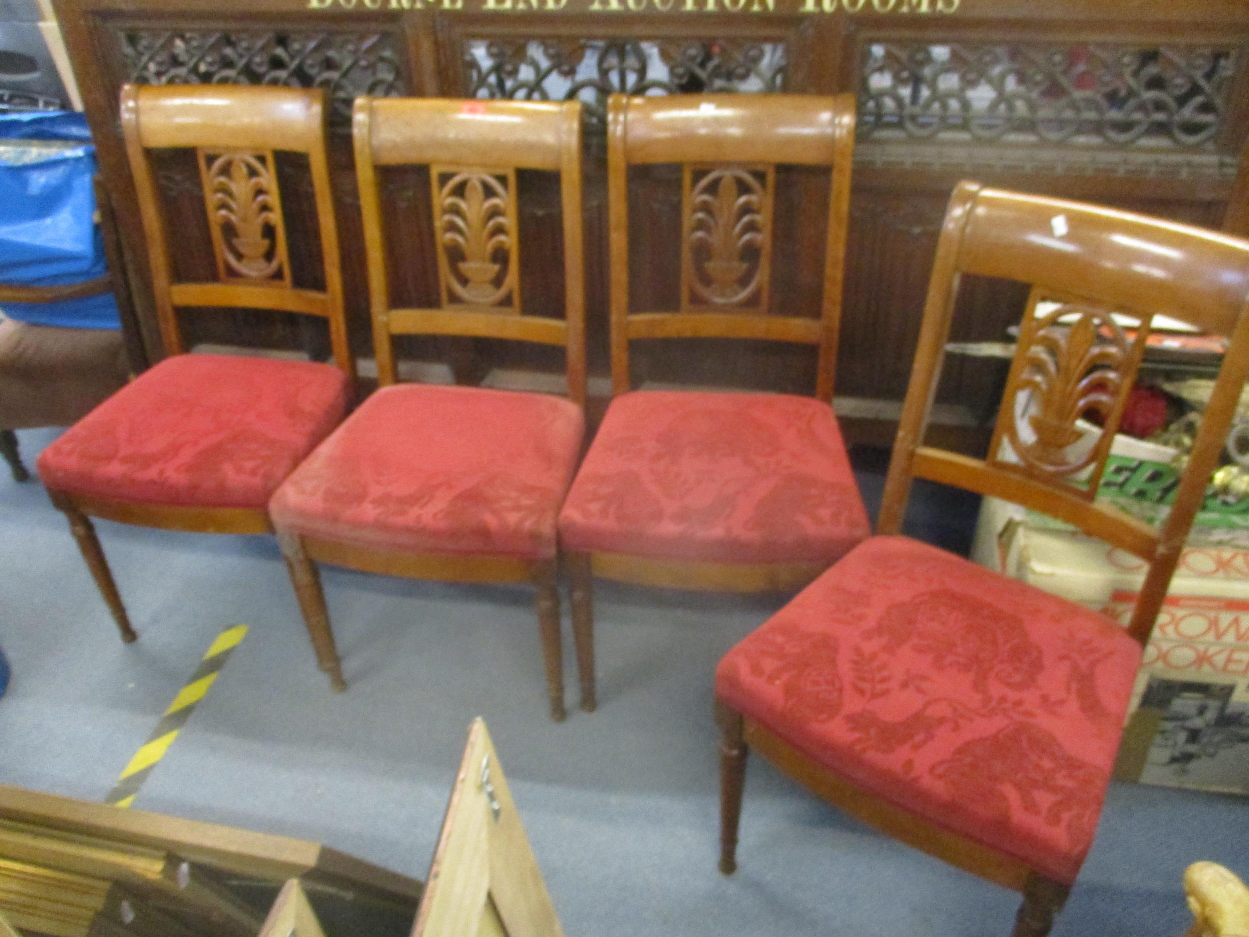 A set of four dining chairs with carved and pierced centre splat, upholstered seat, and turned front