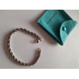 Tiffany & Co-A silver rope twist bracelet intertwined with a fine gold tone chain, 13.9g,