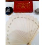 An early 20th Century ivory fan with coat of arms to one fan wand and on the other side of one