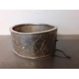 An early 20th Century silver bangle with engraved images of branches to one half with raised birds