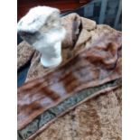 A mid 20th Century brown astrakhan coat and matching hat together with a Saga fox fur peak cap and a