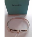 Tiffany & Co-A silver and gold bangle in the belt buckle style stamped 925 and 750, 13.4g, purchased