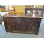 An 18th century oak coffer having three panels with diamond shaped cartouches and carved reeded