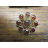 A 19th century yellow gold and garnet cluster brooch in the form of a daisy head, total weight 8/9g,