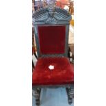 A late Victorian ebonized hall chair in the Carolean style with red upholstered seat and carved back