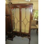 An early 20th century mahogany Chippendale style display cabinet, twin glazed doors above two