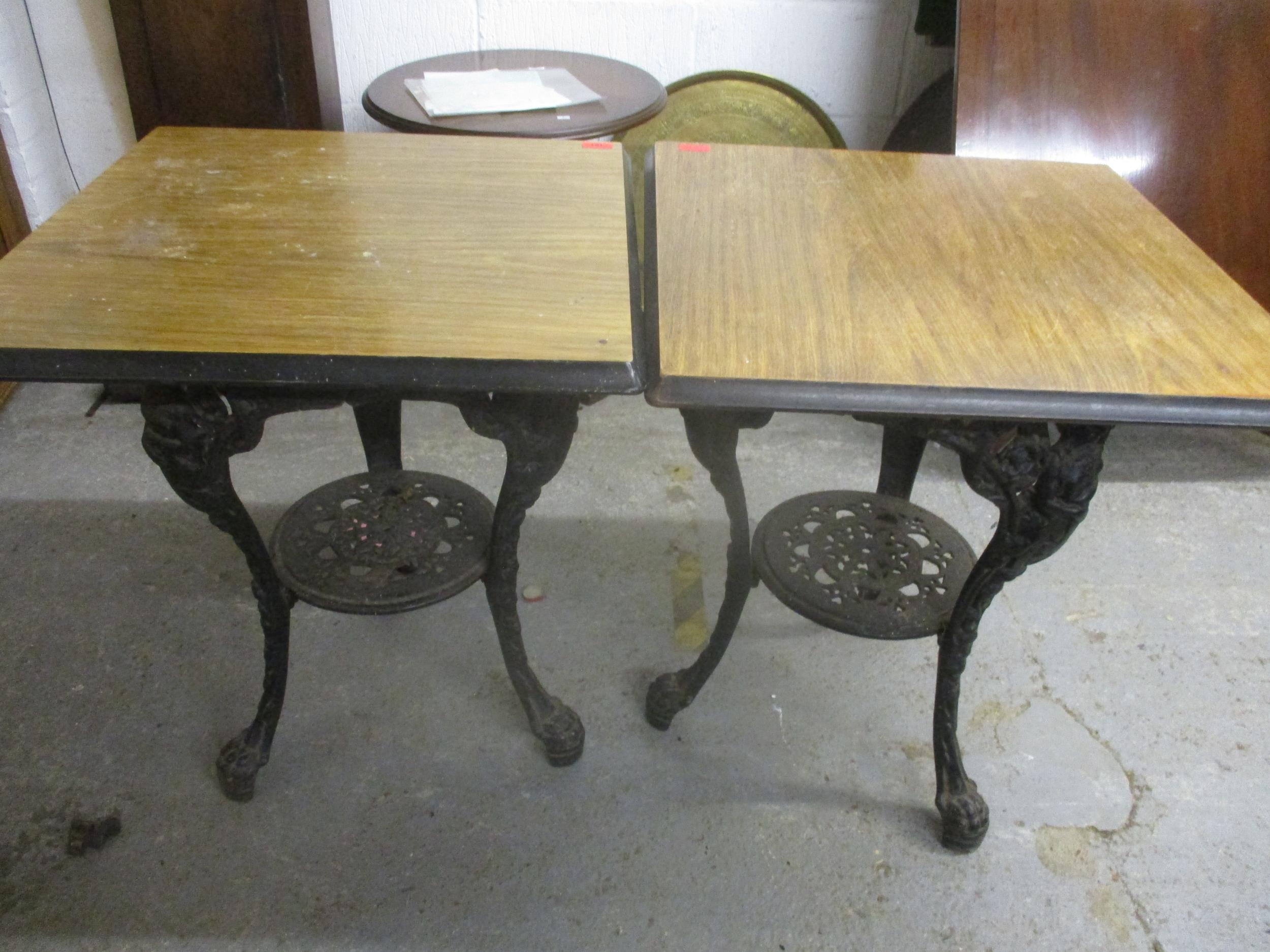 Two cast iron and wooden topped pub tables, 71cm high Location: