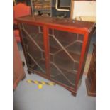 An Edwardian mahogany display cabinet with twin astragal glazed doors, internal wooden shelves, on