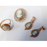A 9ct gold jewellery suite set with cameo style panels comprising a ring, a brooch, and a pair of