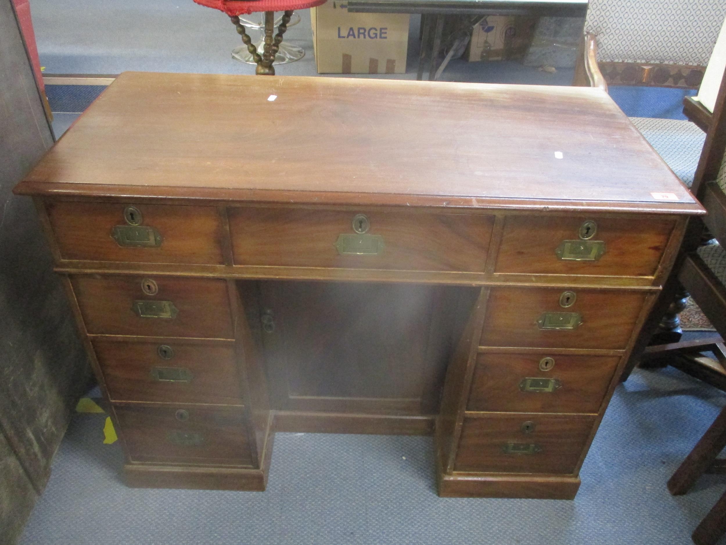 An Edwardian mahogany kneehole writing desk with inset brass handles, fielded cupboard door, one