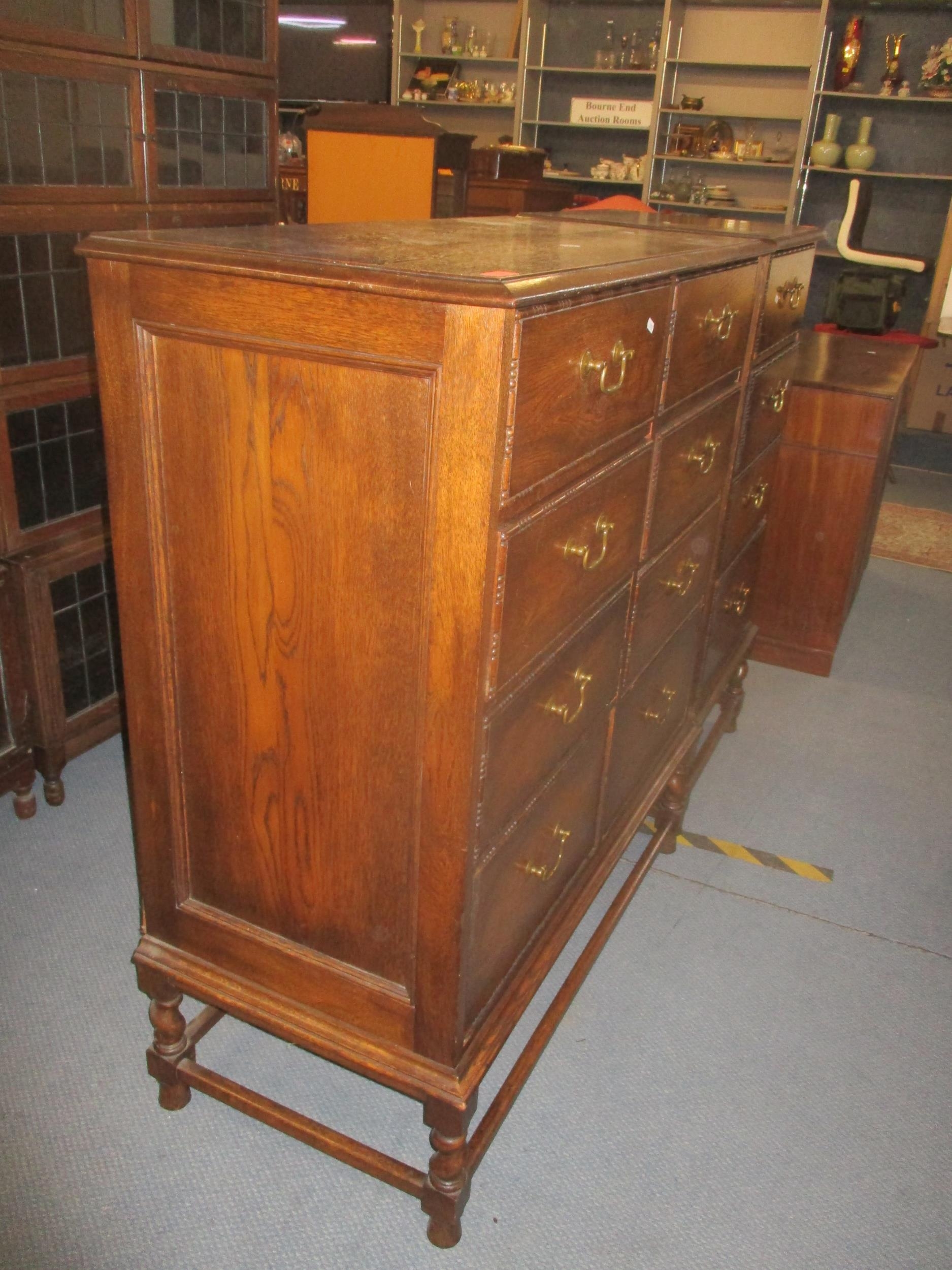 An early 20th century oak side chest of eight short drawers with brass swan neck handles, sausage - Image 5 of 5