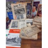 Commemorative ephemera and vintage newspapers reporting significant events, including WWII