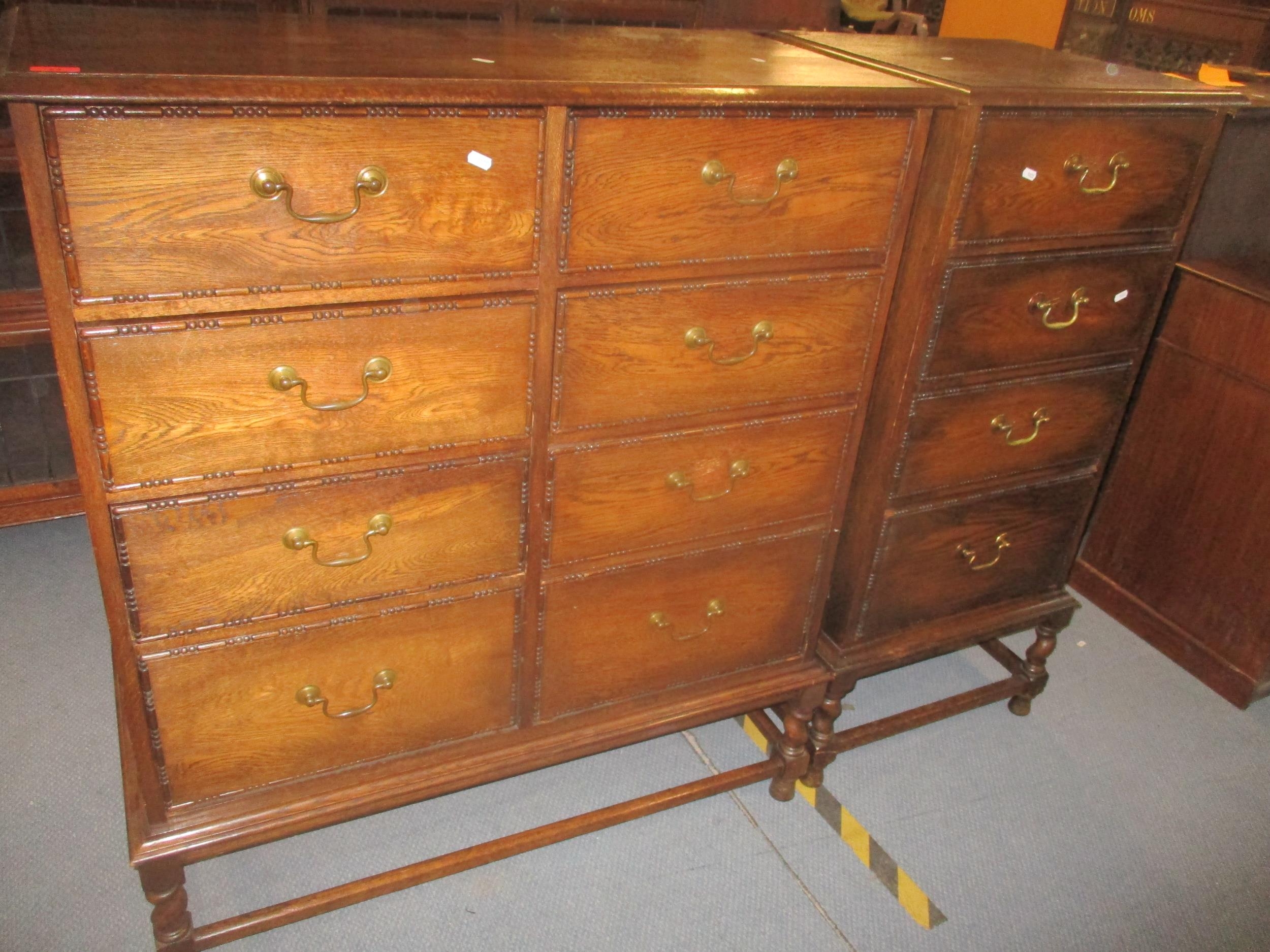 An early 20th century oak side chest of eight short drawers with brass swan neck handles, sausage