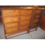 An early 20th century oak side chest of eight short drawers with brass swan neck handles, sausage