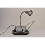 A retro Industrial style desk lamp on a black and chrome stand, with a pen holder, the front with