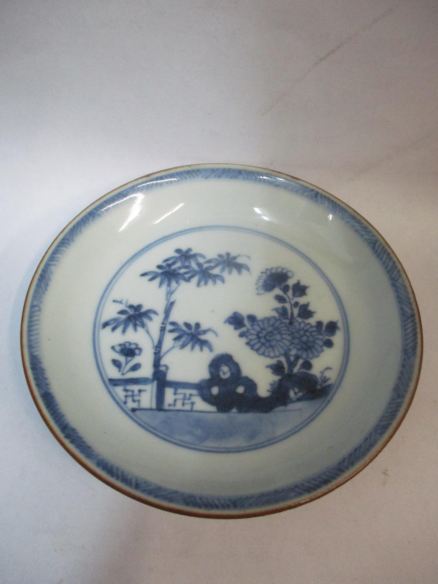 A Nanking Cargo saucer decorated with a garden scene in blue and white Location: