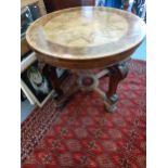 An early 20th century mixed veneered centre table, with a segmented star top on acanthus carved