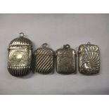 Four silver vesta cases to include a late Victorian example having embossed fluted decoration,