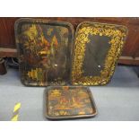 Three black lacquered papiermache trays to include two decorated with Oriental scenes