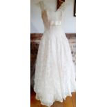 A post 1950's cream lace sleeveless wedding dress with silver coloured thread detail and attached