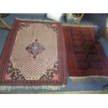 Two rugs to include one having a pink ground with a central motif and tasselled ends, 152 x 114.5