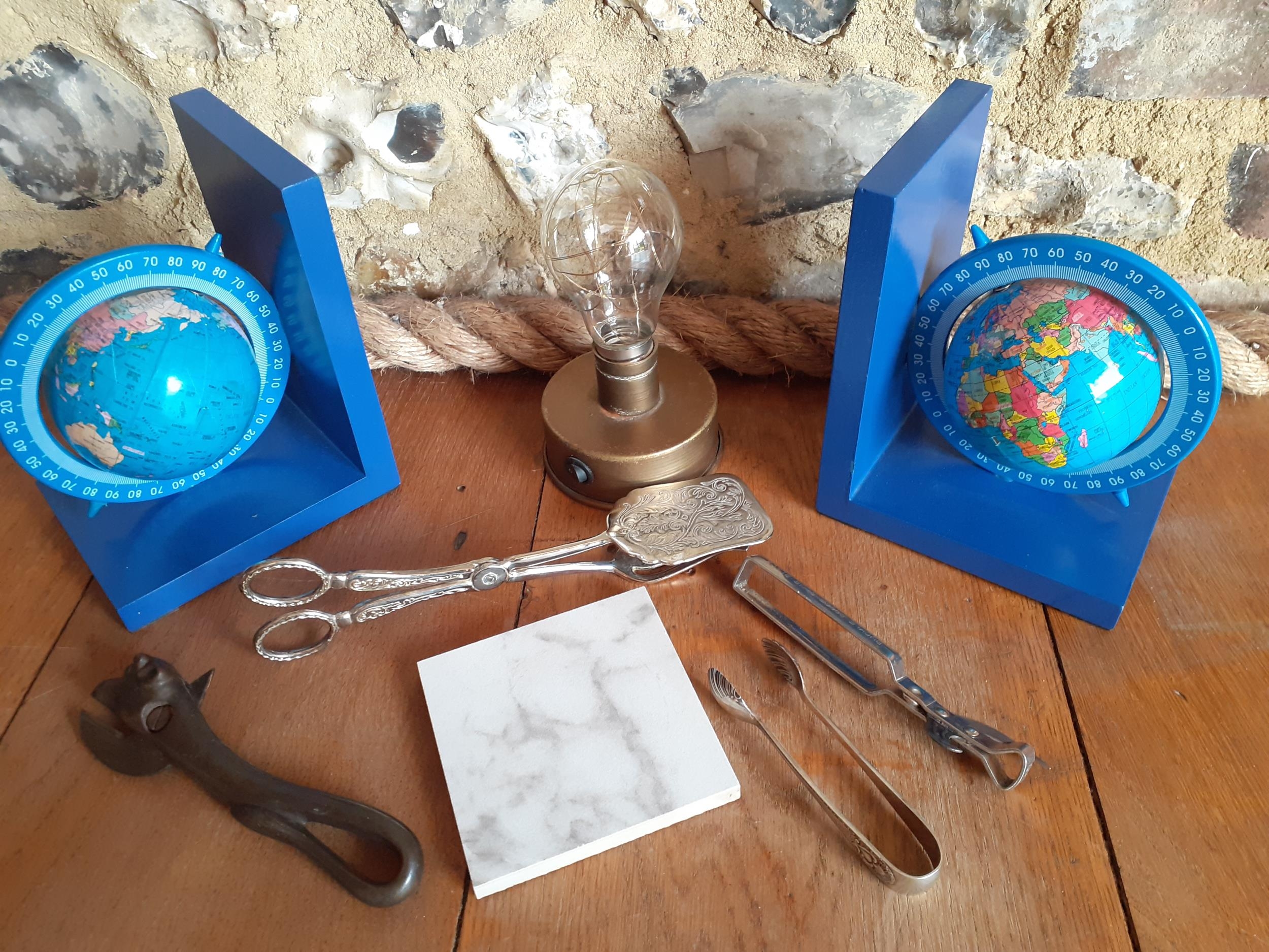A mixed lot to include a pair of globe bookends, silver plated items and a WWI bully beef can opener
