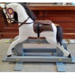 A bespoke rocking horse in white on a grey painted stand with real black horse hair to the mane